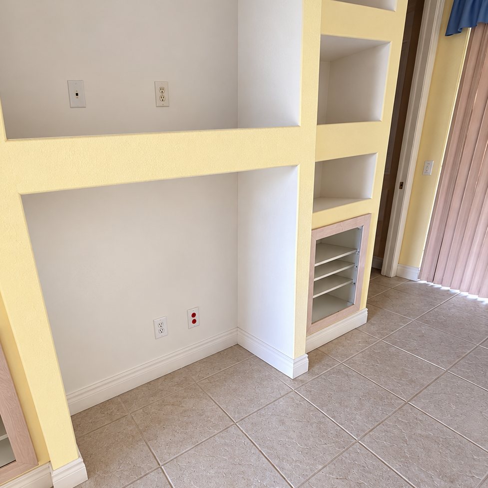 After: the same built-in wall fully cleared, with the TV and cables gone, empty shelves and a bare tile floor.